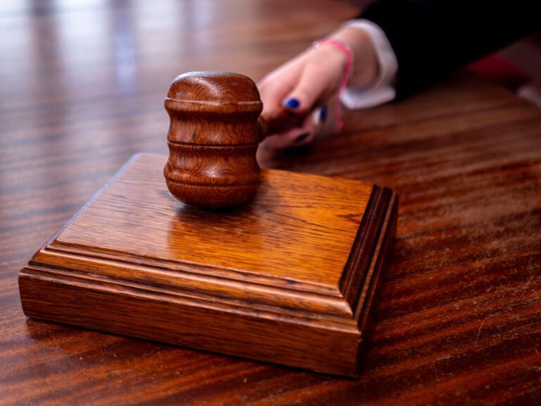 Close-up of a wooden judge's gavel on a desk in a courtroom, symbolizing justice.